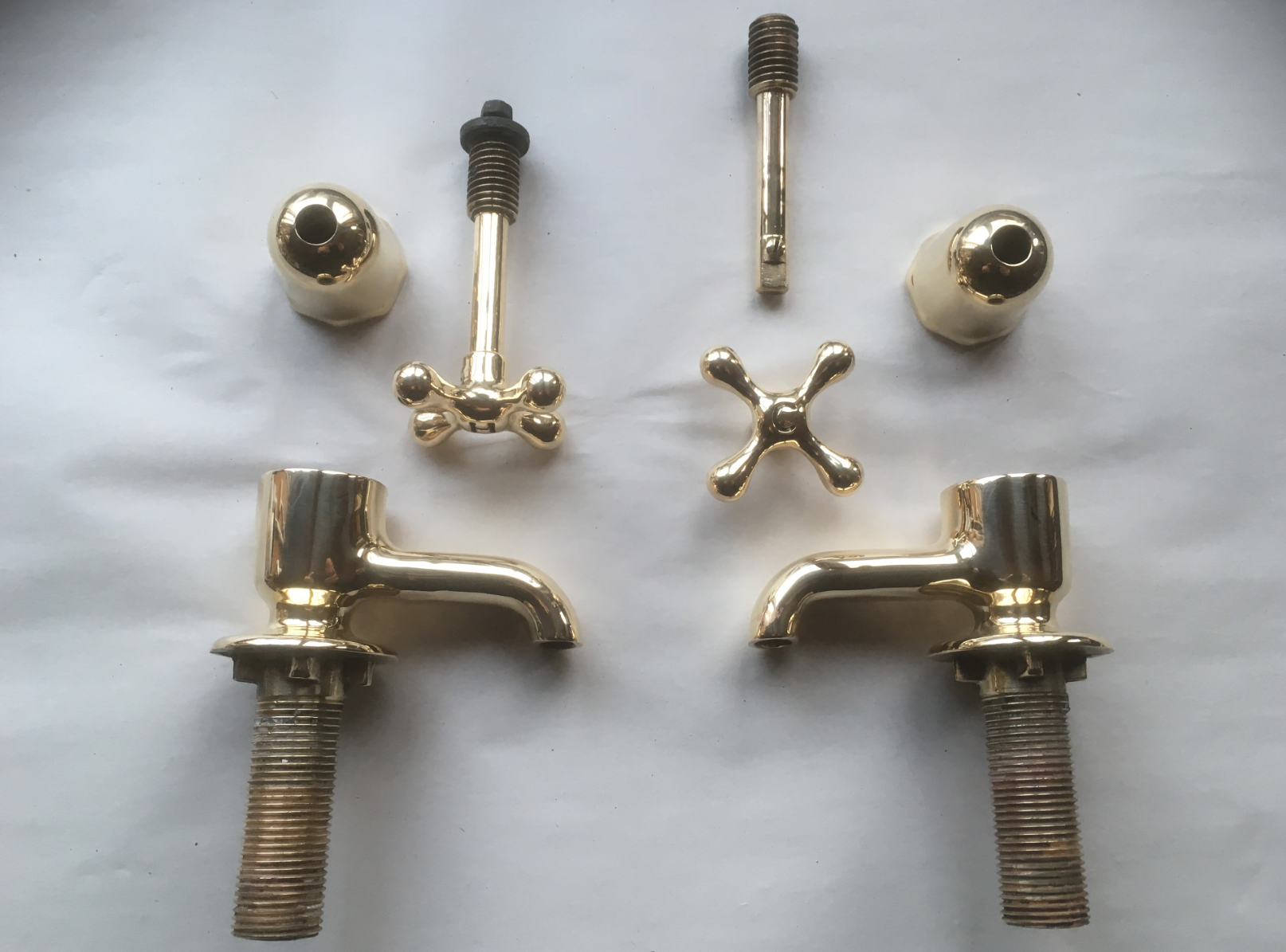 Read more about the article Polished brass basin taps with indented indices.